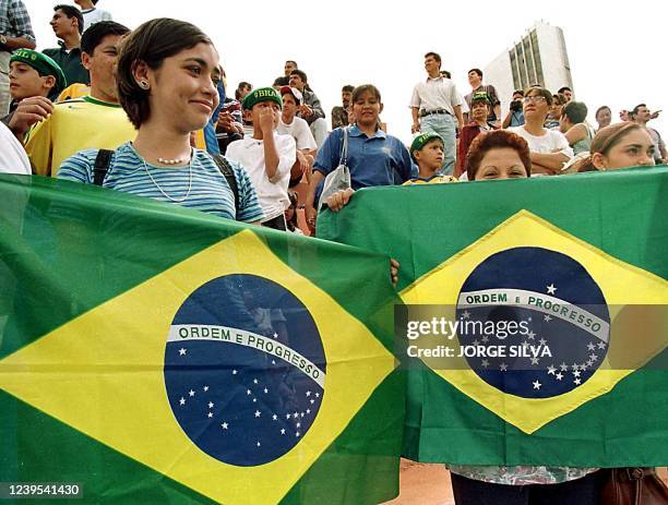 Two Mexican women hold Brazilian flags during a practice match of the Brazilian team in the city of Guadelajara, Mexico 21 July 1999. Dos mujeres...
