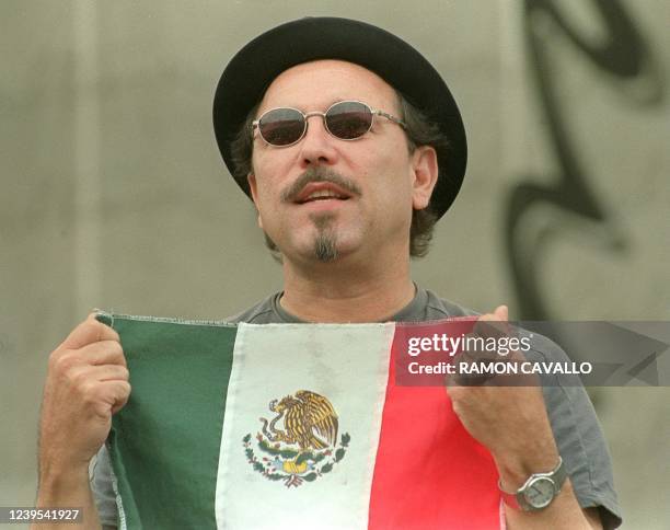 Panamanian singer, Ruben Blades, raises the Mexican flag during a free concert offered at the Constitucion Square, in Mexico City, 08 July 2001. El...