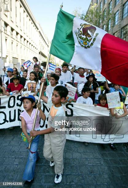 Children are seen raising the Mexican flag in protest of the possible US led war on Iraq 15 March 2003. Dos niños llevan una bandera nacional cuando...