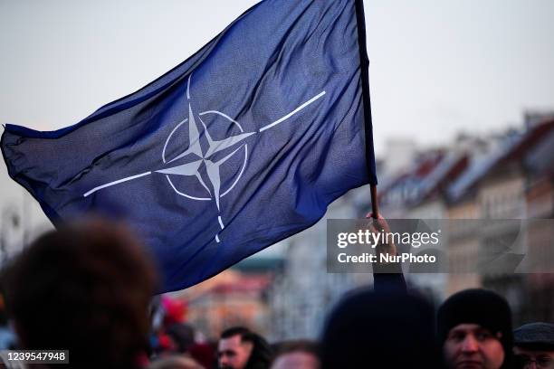 Man holds a NATO flag near the Royal Castle ahead of a speech by US president Joe Biden on March 26, 2022 in Warsaw, Poland. President Biden spent...