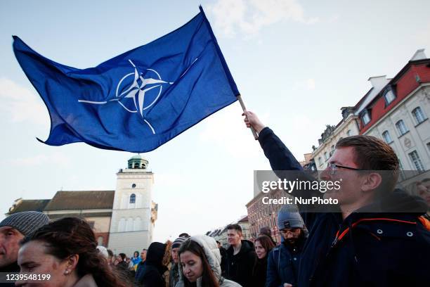 Man holds a NATO flag near the Royal Castle ahead of a speech by US president Joe Biden on March 26, 2022 in Warsaw, Poland. President Biden spent...