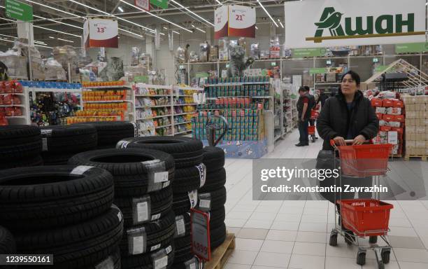 Shopper pushes a trolley with his purchases in front of the Auchan store, March 2022, in Khimki, outside of Moscow, Russia. Privately-owned French...