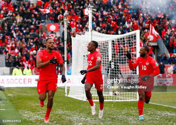 Cyle Larin of Canada celebrates a goal with Richie Laryea and Junior Hoilett during a 2022 World Cup Qualifying match against Jamaica at BMO Field on...