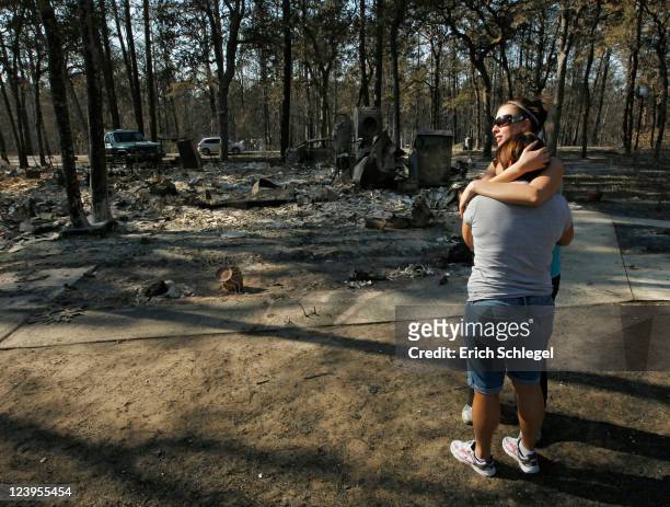 Gaye Jaco hugs her stepdaughter Jennifer Leaver upon returning to their burned down home on the east side of Lake Bastop on September 6, 2011 outside...