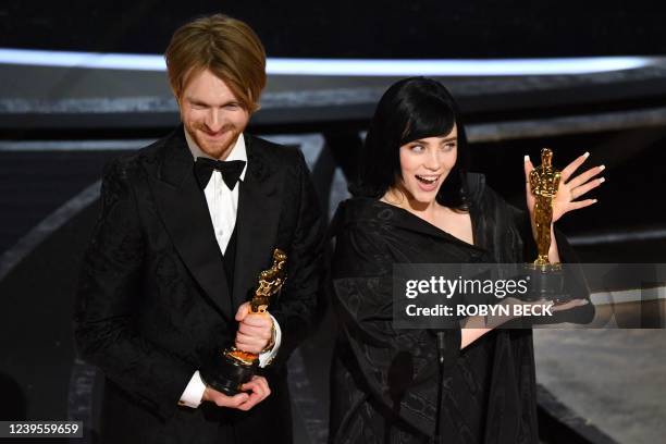 Singer-songwriter Finneas O'Connell and US singer-songwriter Billie Eilish accept the award for Best Music for "No Time to Die" onstage during the...