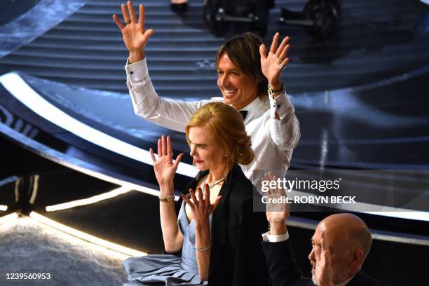 Actor J.K. Simmons , US-Australian actress Nicole Kidman and Australian-US musician Keith Urban applaud the Best Picture award for "CODA" during the...