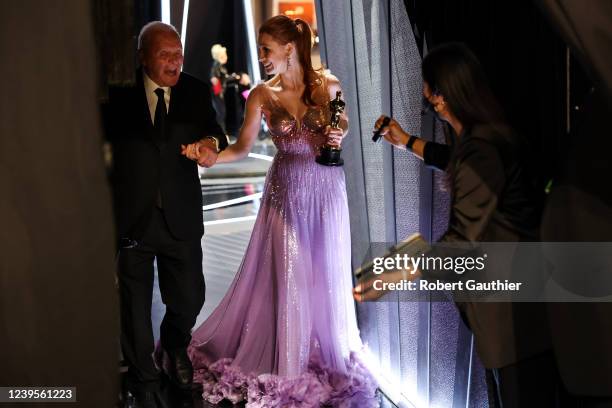March 27, 2022: Jessica Chastain holds her Oscar for best actress as she is escorted back stage by Anthony Hopkins during the show at the 94th...