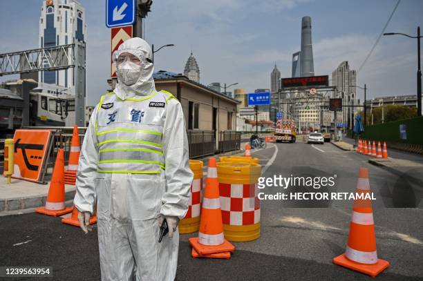 Transit officer, wearing a protective gear, controls access to a tunnel in the direction of Pudong district in lockdown as a measure against the...