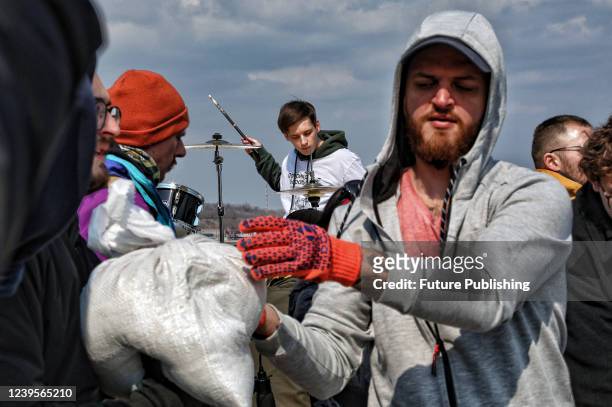 Drummer performs during a concert in support of local volunteers that load sandbags onto trucks, Odesa, southern Ukraine.