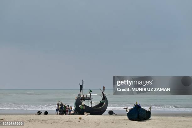 Fishermen try to lift a stranded boat after fishing from the Bay of Bengal in Teknaf on March 28, 2022.