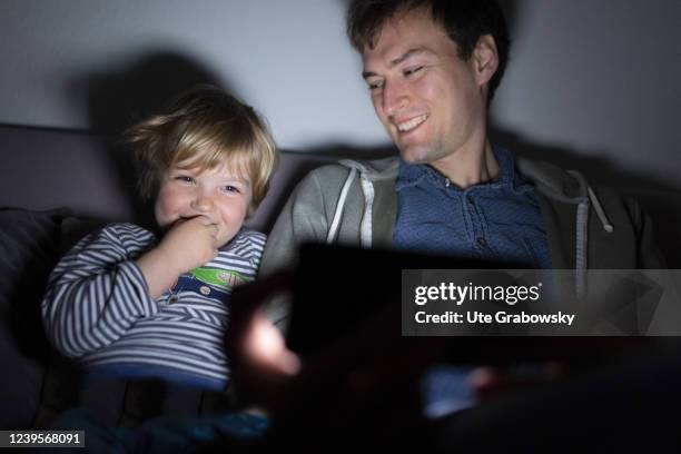 In this photo illustration father and a child are looking on a screen on March 20, 2022 in Bonn, Germany.