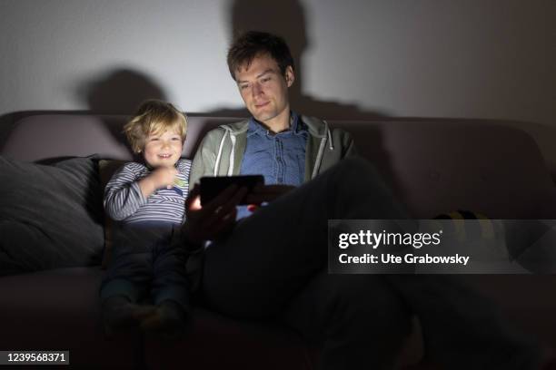 In this photo illustration father and a child are looking on a screen on March 20, 2022 in Bonn, Germany.