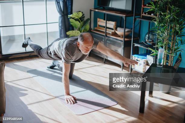 hogere mens die saldooefening doet - home workout stockfoto's en -beelden