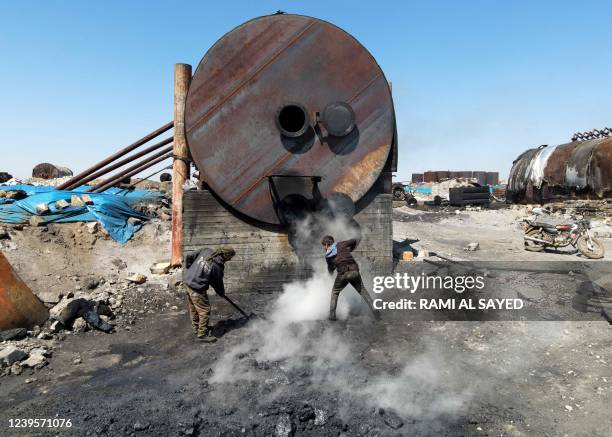 Syrian teenagers work at a makeshift oil refining installation near the city of al-Bab in the north of the Aleppo province, an area of war-torn Syria...