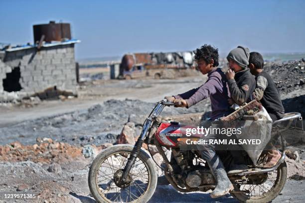 Syrian teenagers arrive to work at a makeshift oil refining installation near the city of al-Bab in the north of the Aleppo province, an area of...