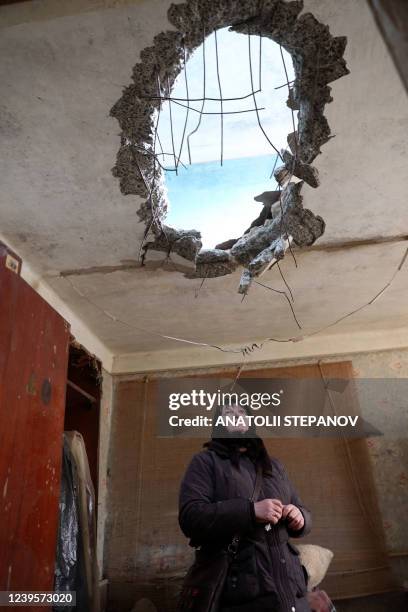 Woman stands in an apartment of a tenement house, damaged by a Russian missile strike in a village on the frontline of the northern part of Kyiv...