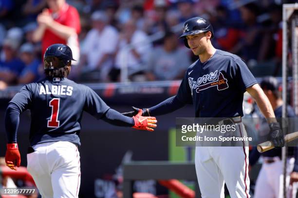 Atlanta Braves second baseman Ozzie Albies is congratulated by first baseman Matt Olson after hitting a solo home run during a spring training...
