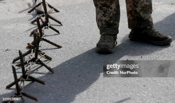 Soldier stands next to obstacles at a roadblock, Kyiv, capital of Ukraine.