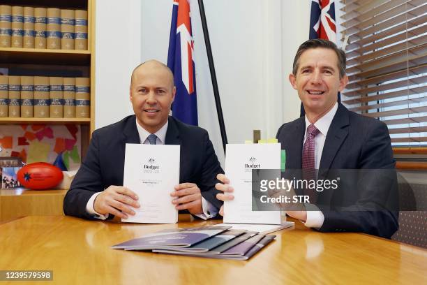 Australia's Treasurer Josh Frydenberg and Finance Minister Simon Birmingham display copies of the federal budget for 2022/23 at Parliament House in...