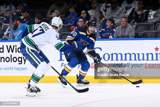 Brandon Saad of the St. Louis Blues controls the puck as Tyler Myers of the Vancouver Canucks defends at the Enterprise Center on March 28, 2022 in...