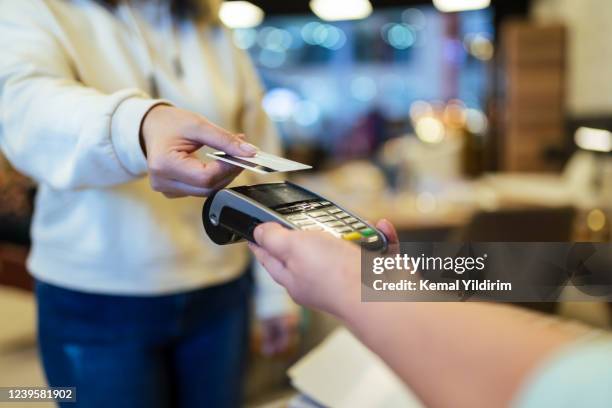 le propriétaire d’un magasin de meubles reçoit un paiement sans contact en raison d’une distanciation sociale - carte de crédit photos et images de collection