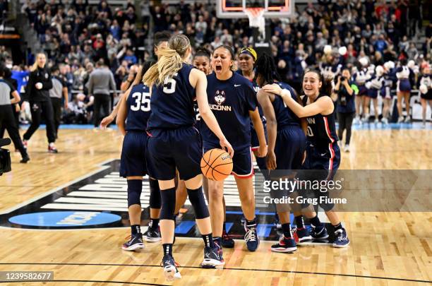 The Connecticut Huskies celebrate after a victory against the N.C. State Wolfpack during the Elite Eight round of the 2022 NCAA Womens Basketball...