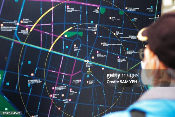 Man checks a Taipei map on the street at Ximen district in Taipei on March 29, 2022.