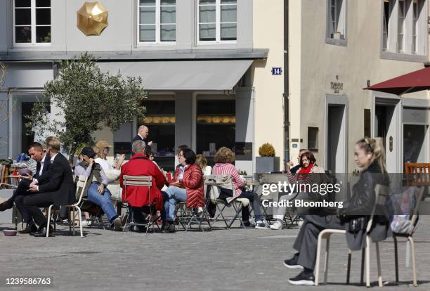 Customers at a cafe outdoor terrace area on a pedestrianized square in Zurich, Switzerland, on Monday, March 28, 2022. Switzerland trimmed its growth...