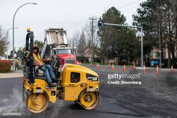 Steam roller compacts newly laid asphalt on a road in Victoria, British Columbia, Canada, on Thursday, March 24, 2022. The province is working to...