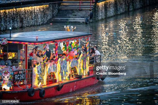 Locals and tourists on a bumboat tour on the Singapore River in Singapore, on Tuesday, March 29, 2022. Singapore today significantly eases Covid-19...