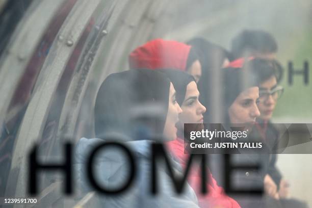 Afghan development squad team players watch from duggout the football match between Afghan development squad and Womens parliamentary team, at the...