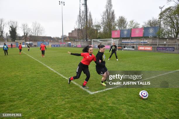 Afghan development squad team player fights for the ball with Womens parliamentary team player during the football match between Afghan development...