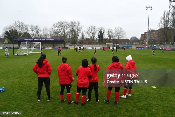 Afghan development squad team players stand on the sidelines to watch the football match between Afghan development squad and Womens parliamentary...