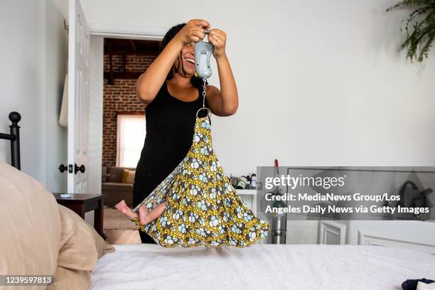 Midwife Allegra Hill weighs Aysha-Samon Stokes two-week-old son Nikko during a postpartum visit to her South Los Angeles birthing center, Kindred...