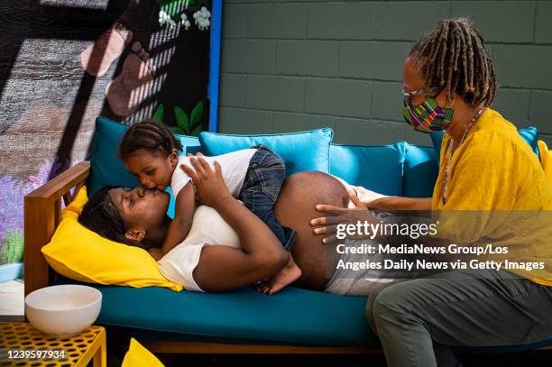 Aysha-Samon Stokes son Wyatt, 17 months, jumps on her as her Midwife Kimberly Durdin begins to check her baby at Kindred Space LA, a birthing center...