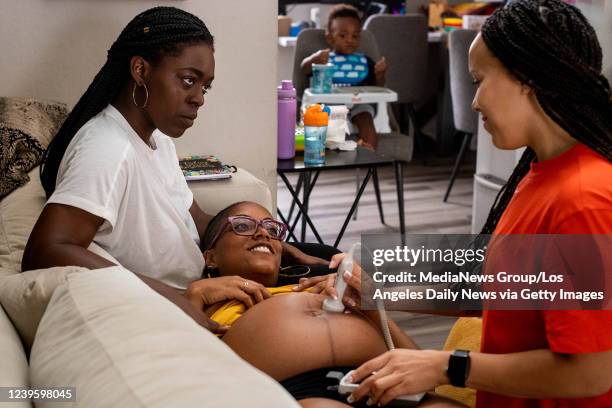 Fountain Valley, CA Midwife Angie Miller listens to the heart beat of MyLin Stokes Kennedys baby with her wife Lindsay and their child Lennox, 21...