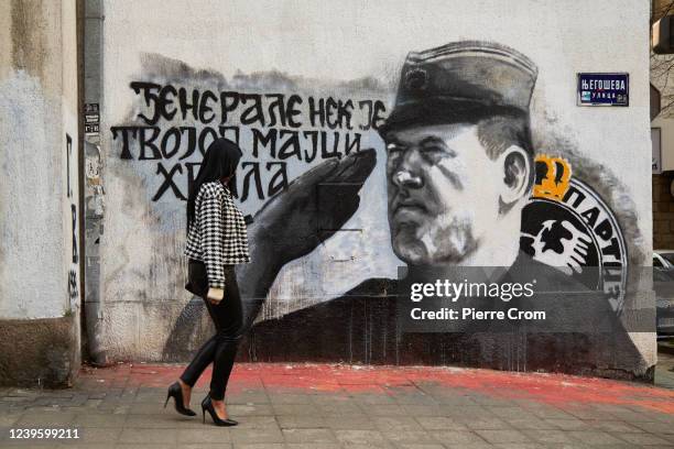 Resident walks pass a mural of Bosnian Serb convicted war criminal Ratko Mladic on March 29, 2022 in Belgrade, Serbia. Serbia will hold an early...