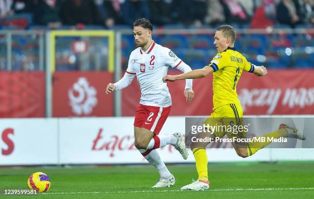 Ludwig Augustinsson of Sweden tackles Matthew Cash of Poland during the 2022 FIFA World Cup Qualifier knockout round play-off match between Poland...