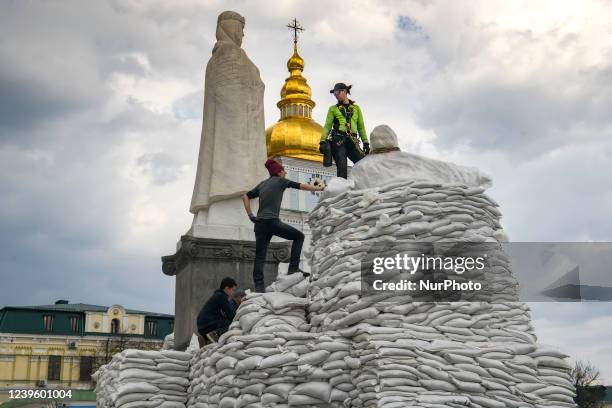 Volunteers cover a monument of the Princess Olga, Apostle Andrew, Cyril and Methodius of sand bags for protection as Russia's invasion of Ukraine...
