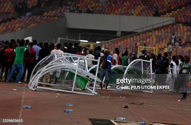 Angry football fans break the players' bench as violence broke-out following Ghana's defeat over Nigeria at the World Cup 2022 qualifying football...