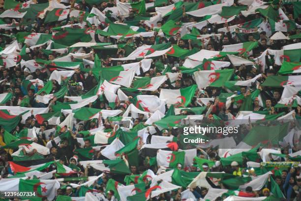 Algeria's fans wave flags during the second leg of the 2022 Qatar World Cup African Qualifiers football match between Algeria and Cameroon at the...