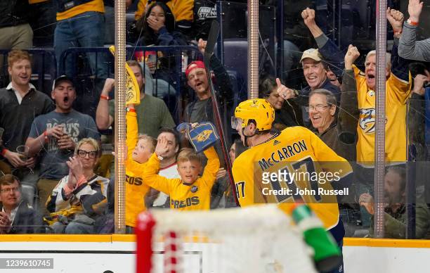 Nashville Predators fans celebrate with Michael McCarron after his goal against the Ottawa Senators during an NHL game at Bridgestone Arena on March...