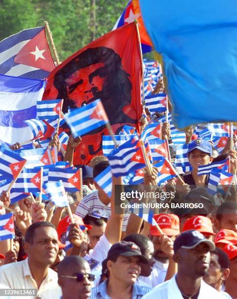 Cubans participate in a march with a picture of Che Guevara and Cuban flags, 01 May 2000 in the Revolution Plaza in Havana, on the International Day...