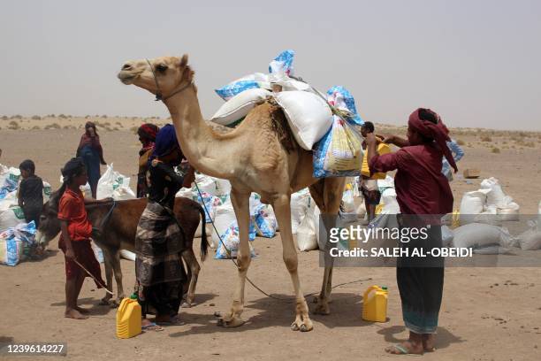 Poor Yemeni families receive flour rations and other basic food supplies from charities in the province of Lahj, in southern Yemen, on March 29 as...
