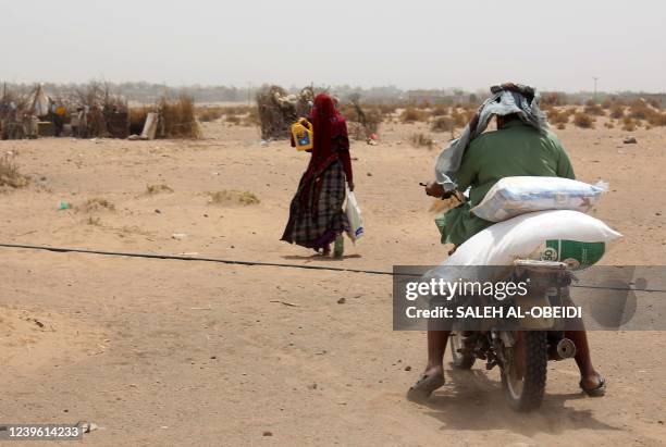 Poor Yemeni families receive flour rations and other basic food supplies like rice, oil and sugar, from charities in the province of Lahj, in...