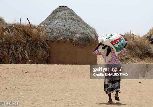 Displaced Yemeni, receives food aid and supplies at a camp in Hays district in Yemen's war-ravaged western province of Hodeida on March 29 as food...