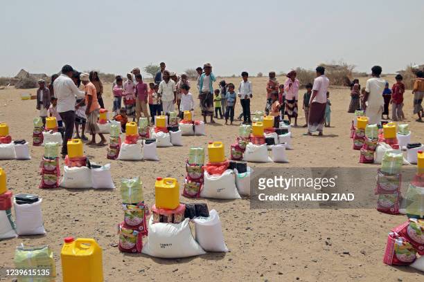 Yemenis displaced by the conflict, receive food aid and supplies to meet their basic needs, at a camp in Hays district in the war-ravaged western...