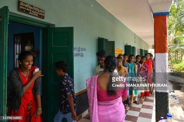 School students stand in a queue outside a classroom to get themselves inoculated with the jab of Corbevax vaccine, during a vaccination drive held...