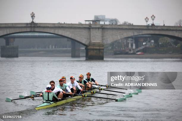 The Cambridge University men's boat row toward Putney Bridge as they train early in the morning on the River Thames in London on March 30 ahead of...