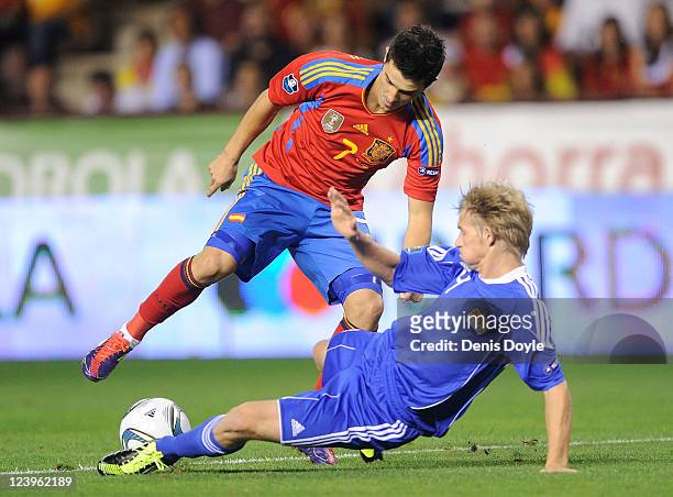 David Villa of Spain is tackled by Martin Rechsteiner of Liechtenstein during the EURO 2012 Qualifier match between Spain and Liechtenstein at...
